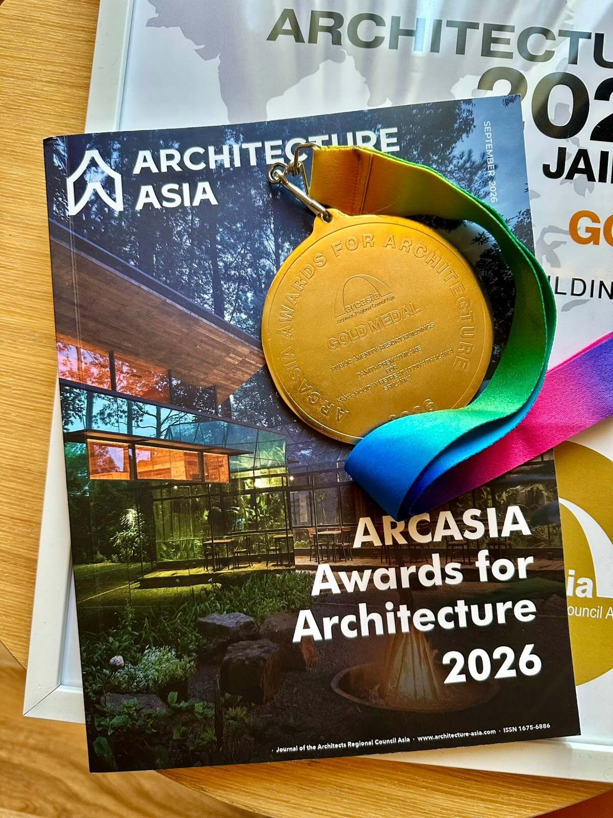 ARCASIA Gold Medal resting on the September 2026 issue of Architecture Asia, with KAYA Retreat on the cover